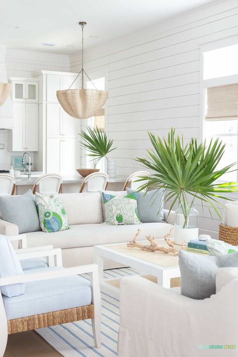 A coastal living room with linen sofas, blue and white striped rug, raffia coffee table and rope chandelier. Accented with blue and green decor. The shiplap walls are painted Sherwin Williams Snowbound. Neutral Coastal Living Room, Life On Virginia Street, Modern Coastal Home, Coastal Decorating Living Room, Modern Coastal Decor, Coastal Living Rooms, Coastal Living Room, Modern Coastal, Florida Home