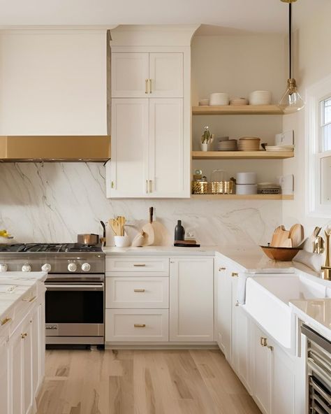 Happy Monday!! ✨✨✨ This kitchen exudes a timeless and muted elegance. The cabinetry is off-white, paired beautifully with light wood flooring, creating a serene and inviting atmosphere. The countertops and backsplash are made of quartz, adding a touch of luxury. Open shelving displays neatly arranged dishes and kitchenware, enhancing the minimalist aesthetic. The gas stove and gold-coloured accents, such as the cabinet handles and pendant light fixture, add both functionality and style to th... White And Wood Kitchen Brass Hardware, White Wood And Gold Kitchen, White Gold And Wood Kitchen, Kitchen Design White And Gold, Kitchen Cabinets With Gold Handles, Off White Kitchen Cabinets With Quartz, White Kitchen Cabinets With Quartz, Vanilla Kitchen, Adu Kitchen