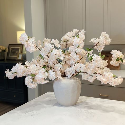 Transform your home into a stunning spring oasis with our full cherry blossom branch! Featuring life-like branches and fully bloomed waterfall blossoms in the softest shades of pink and white, this artificial stem is sure to make a statement. The petals are soft to the touch, and the big, beautiful blossoms pack a punch to create a truly stunning effect. Plus, the branch itself has texture and variety to look incredibly realistic, and the high-quality materials used in its creation ensure that t Cherry Blossom Centerpieces, Cherry Blossom Dining Table Decor, Cherry Blossom House Decor, Dining Table Centerpiece Elegant, Dining Table Flowers, Faux Cherry Blossom Tree Wedding, Pink Waterfall, Cherry Blossom Centerpiece, Cherry Blossom Branches In Vase