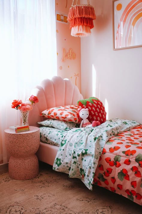 This toddlers room is glowing from the pink and red colours uses to style it. I have used kip and co’s strawberry quilt cover and strawberry cushion to add some more red into the room. The pink terrazzo side table is styled with pink and red roses and then some kids wall art with red orange and pink rainbows. The tassel chandelier i hand made myself and used red peach and oranges. Follow the link for more on this room. Preppy Cottage Core Bedroom, Kip And Co Bedding, Pink And Red Kids Room, Pink Orange Nursery, Strawberry Bedroom Ideas, Pink And Red Girls Bedroom, Bright Toddler Girl Room, Red Toddler Room, Toddler Girl Room Colorful