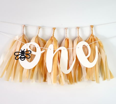 This bee 🐝 set is perfect for layering on a high chair or using as a backdrop for your little one's photo or smash cake session! The banner comes with CREAM letters and a black bee detail. The mini tassels are mustard, french vanilla, cream. Choose to purchase: *ONE banner only *6 Mini Tassels only *Or BOTH banner + (6) mini tassels Letters made from heavy duty cardstock Approx. 4 inches tall Mini Tassels made from tissue paper Approx. 9 inches long Both items will come prestrung on twine for easy hanging. **knoba studio's items are made to order. If you are purchasing an item for an event that is less than two weeks away, please send us a message before purchasing to ensure production time and/or to purchase a rush order. We do not accept returns due to the delicate nature of the item bu Honey Bee Party Decorations, Honey Theme Birthday Party, Bumblebee Party, Honey First Birthday Party, Bee Theme 1st Birthday, Honey Bee Birthday Party Decorations, First Bee Day Party Food, Bee One Birthday Party, One Year Old Birthday Bee Theme