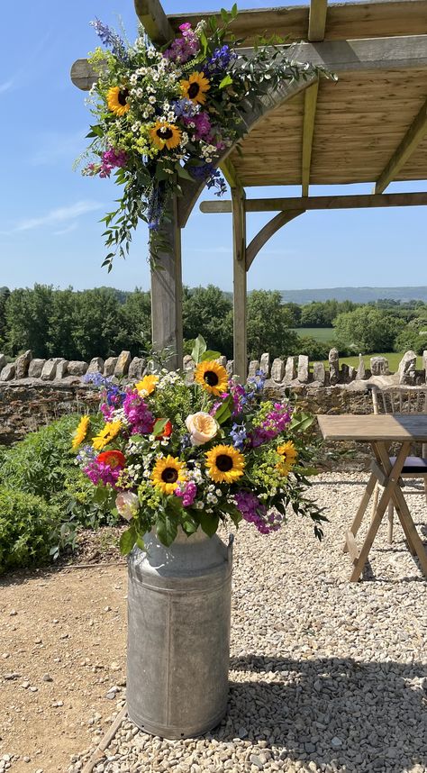 A perfect summer's day, with meadow style, colourful blooms decorating the arch. Wildflower Decor Wedding, June Wedding Centerpieces Diy, Country Style Wedding Flowers, Wedding Barrier Ideas, Meadow Themed Party, Colourful Outdoor Wedding, Wedding Arbor Wildflowers, Summer Wild Flower Wedding, Meadow Wedding Decoration