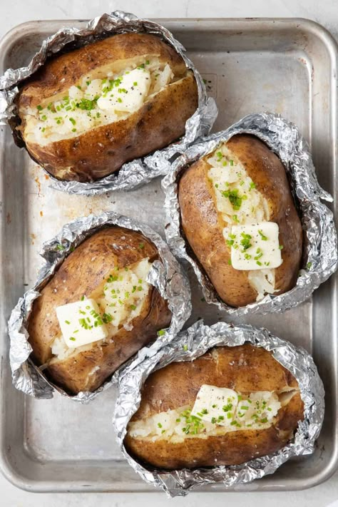 Turn a humble potato into a smokin' sensation! This crispy, fluffy baked potato on the grill is perfect for your next backyard cookout. | Grilled Baked Potatoes | Baked Potato on Grill | How to Grill Potatoes | Grilled Baked Potatoes in Foil | Potatoes For Bbq, Barbeque Potatoes, Baked Potato On Grill, Grilling Baked Potatoes In Foil, Potato On Grill, Campfire Baking, Feelgoodfoodie Recipes, Potato On The Grill, Baked Potatoes On The Grill