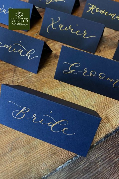 Navy Blue tent fold wedding place cards with Gold Calligraphy. Available to purchase in the online Etsy store, each place card is lettered by hand with wedding guest names #laneyslettering #placecards #tentfoldcards #tablescape #tablesetting #weddingcalligraphy #weddingideas #bluewedding #diywedding #placenames #escortcards #placesettings #weddingplanning Name Cards Table, Place Cards For Wedding, Calligraphy Place Cards, Place Setting Cards, Cards For Wedding, Handwritten Wedding, Wedding Place Names, Table Name Cards, Table Place Settings