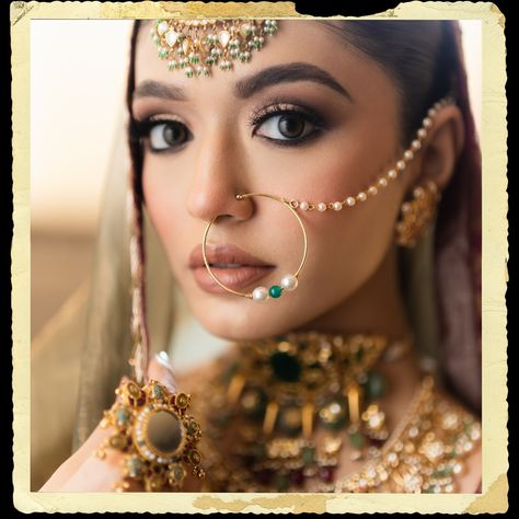 The intricate maang tikka, with its detailed gold work and delicate hanging pearls, graces her forehead, perfectly complemented by the large, ornate nath (nose ring) that adds a classic touch of elegance. Her neck is beautifully accentuated by a layered choker necklace, encrusted with a blend of precious stones and elaborate filigree designs, epitomizing luxury and grandeur. The look is completed with statement earrings, an opulent ring, and a pair of intricately designed bangles, all contrib... Wedding Nose Ring Brides, Nath Bridal, Bridal Nath, Nath Nose Ring, Bridal Nose Ring, Bridal Jewelry Sets Brides, Indoor Ideas, Rose Gold Bridesmaid, Punjabi Bride