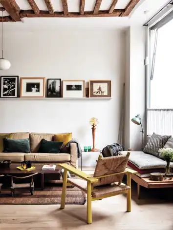 The living room, once part of a shop, has windows onto the street. The rug is a traditional Tuareg design made from straw and leather; the yellow chair is a prototype made by Camille. Camille uses picture ledges so that she can swap around displays easily. Gallery Shelf, Vintage Scandinavian Furniture, Duplex Apartment, Interior Windows, Apartment Architecture, Parisian Apartment, Paris Apartments, Scandinavian Furniture, Tiny Bedroom