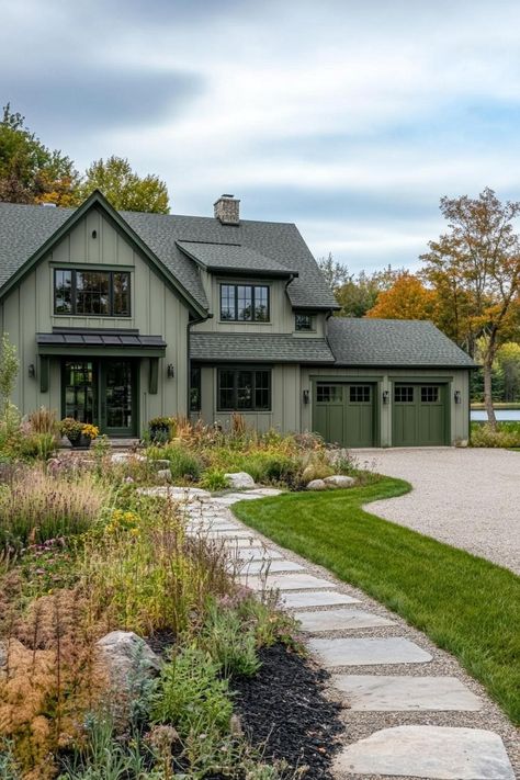 Wide angle view of a large modern farmhouse exterior in greyish pale green board and batten siding slightly darker sage green barn doors and window. Check out all of these dream farmhouses that will have you drooling with rural living fantasies and mooing with joy! Green Board And Batten Vinyl Siding, Olive Green Exterior House Colors Board And Batten, Light Green Board And Batten Exterior, Farmhouse Board And Batten Siding, Sage Green Farmhouse Exterior, Dark Green Board And Batten Exterior, Green Exterior Homes, Moody Farmhouse Exterior, Green Exterior Siding