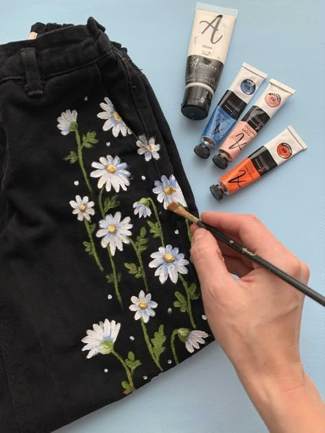 Acrylic Shirt Painting, Acrylic Painting On Pants, Daisy Jeans Outfit, Painting On Black Shirt, Fabric Painting On Jeans Pants, Jean Pants Painting Ideas, Acrylic Jeans Painting, Diy Paint On Clothes, Painting On Shirts Diy