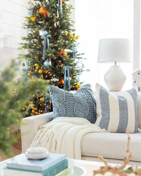 Cozy Coastal Christmas, Orange And Blue Christmas, Blue Orange Christmas Tree, Blue And Orange Christmas, Blue Couch Living Room Christmas Decor, Light Blue Christmas Tree, Evergreen Citrus Boho Christmas, White And Blue Christmas Tree, Costal Christmas Decor House