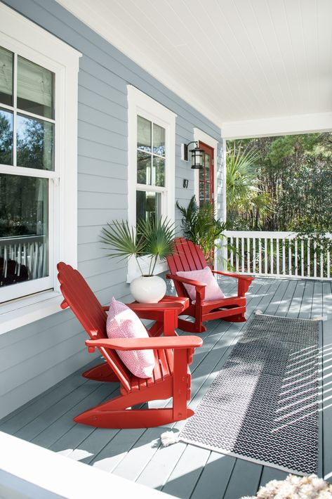 A comfortable coastal porch featuring Benjamin Moore Nimbus Gray 2131-50 and Caliente AF-290, the perfect paint colors for a look that is fun, but still traditional for the exterior of your home. Nimbus Gray, Renovation Exterior, Red Chairs, Porch Paint, Deck Colors, Deck Paint, Painted Patio, Pintura Exterior, Exterior Paint Color