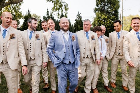 Groom wearing a blue linen suit whit white tie and pampas grass boutonniere. The groomsmen wore tan suits with blue ties and matching boutonnieres for this The Cordelle wedding in Nashville, TN | John Myers Photography & Videography Tan And Dusty Blue Groomsmen, Light Blue Bridesmaid Tan Groomsmen, Tan Suit With Blue Tie, Blue And Tan Groomsmen, Tan Suits Groomsmen, Blue And Tan Wedding Party, Tan Suit Groomsmen, Pampas Grass Boutonniere, Khaki Groom