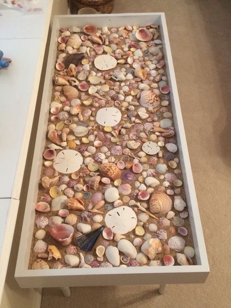 Seashell coffee table - Ugly, old shadow box table that I painted white, added sand, and added seashells I collected in Sanibel, FL (glass not placed here).....Inspired by: https://www.primeriti.es/blog/decoideas/ideas-para-decorar-con-conchas-marinas/ Seashell Resin Table, Display Table Ideas, Seashell Table, Shadow Box Table, Shadow Box Coffee Table, Diy Coffee Tables, Seashell Display, Shell Display, Seashell Projects