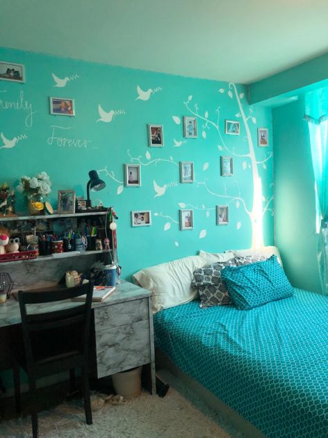 Turquoise room with tree mural painting and photo frames. Marble desk with shelf decorations. Fluffy white carpet. Bed with turquoise sheets and pillows. Pretty turquoise curtain. Photo Frames On The Wall Bedroom Beds, Cyan Room, Ocean Room Ideas, Aesthetic Turquoise, Turquoise Bedroom, Turquoise Curtains, Desk With Shelf, Teal Rooms, Shelf Decorations