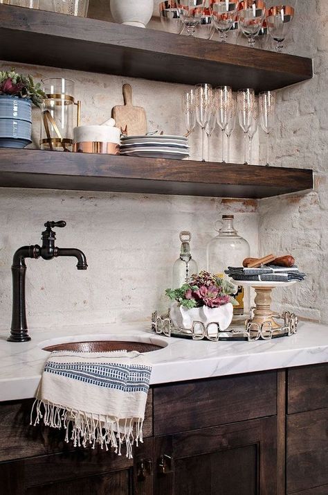 The rustic wood of the cabinets here really contrast with the marble and that is a really stylish look. The dark colors and the old-style faucet really help enhance that idea too. Painted Brick Backsplash, Backsplash With Dark Cabinets, Farmhouse Kitchen Backsplash, Bar Mini, Farmhouse Interior Design, Herringbone Backsplash, Brick Backsplash, Farmhouse Kitchen Cabinets, Rustic Farmhouse Kitchen