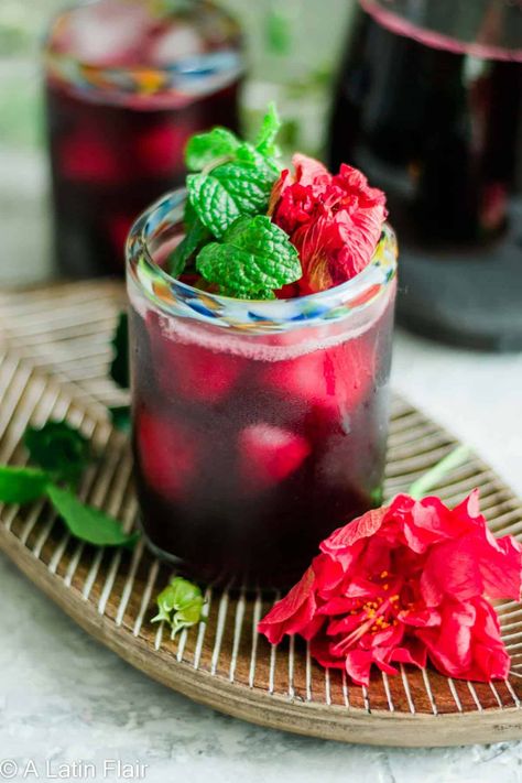 Agua de Jamaica (Homemade Hibiscus Iced Tea). Sweet. Tart. Refreshing. Full of Mexican tradition. The most popular Agua Fresca in Mexico! Only 3 ingredients and 15 minutes to make! #alatinflair #aguadejamaica #hibiscustea alatinflair.com Agua Fresca Jamaica, Homemade Agua Fresca, Flowers Mexico, Hibiscus Iced Tea, Organic Lemonade, Agua Fresca Recipe, Jamaica Food, Kid Friendly Drinks, Dried Hibiscus Flowers