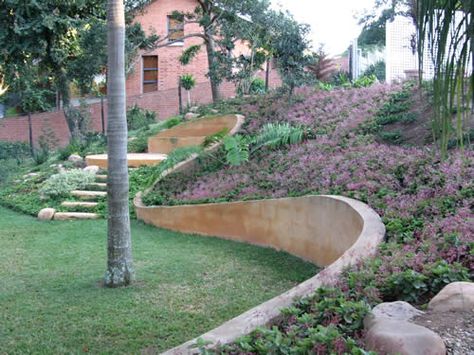 "Curved retaining wall." Hints of a cinder block wall that's been stucco'd over? Curved Retaining Wall, Cinder Block Bench, Building A Retaining Wall, Cinder Block Walls, Concrete Retaining Walls, Landscaping Retaining Walls, Front Yard Fence, Stucco Walls, Cinder Block