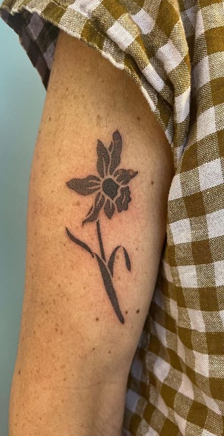 Black Filled Tattoo, Adonis Flower Tattoo, Earthy Arm Tattoos, Trumpet Creeper Tattoo, Tattoo Ideas Daffodil, Wrap Around Elbow Tattoo, Men’s Flower Tattoo, Finger Tattoos Flower, Tattoo Ideas Cover Up