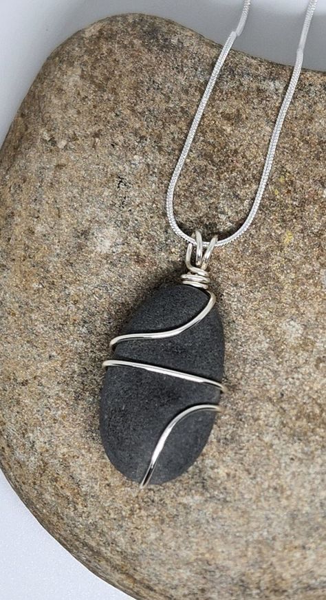 Minimalist, earthy, smooth natural river pebble, artfully wrapped in silver wire, either plated or .925 sterling silver. The wire is coated to inhibit tarnishing and keep your piece looking great. Complimentary 18" plated or .925 sterling silver necklace included (I do have 24" and 30" snake chains if you prefer a longer length; just let me know in the message section). Each piece is created in my studio and is unique and one of a kind! Because each item is made by hand, please allow for slight Polished Rock Jewelry, Handmade Stone Jewelry, Diy Rock Jewelry, Wrapped Rocks Tutorial, Rock Jewelry Diy, Wire Wrapped Rocks, Crystal Jewelry Ideas, Hammered Wire Jewelry, Wrapping Stones