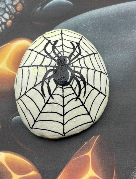 Glow in the Dark Spider in Spiderweb, Halloween Art Decor, Painted Rock, Stone Painting Measures approximately:  Height 3" Length 2.5" Depth .75" ✽ My painted rocks are natural creek rocks collected locally in middle Tennessee and hand painted by me.  ✽ Your stones are handpicked and hand painted by me with love! Each is a one-of-a-kind piece of art! I hope they bring much joy, happiness, and a smile to you.   ✽ These are natural creek rocks so each stone is unique and no two rocks are identical.  The size, shape, and texture may vary slightly. ✽ Each stone design is drawn by hand, painted with acrylic paints, sealed, and packaged with care to send to your home from my home in middle Tennessee.   ✽ All my creations are sealed to protect and preserve the quality. ✽ Want a custom design?  If Scary Rock Painting, Painted Rocks Halloween, Skull Rock Painting, Halloween Rocks Painted Ideas, Cute Painted Rocks, Halloween Rock Painting Ideas, Halloween Painted Rocks, Halloween Kunst, Halloween Rocks