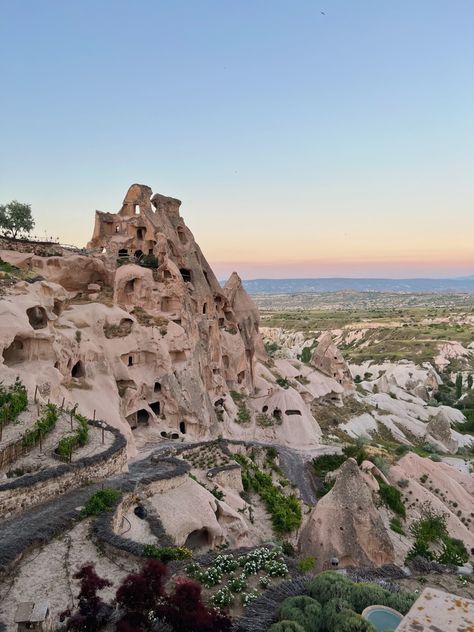 The image shows a natural rock formation and landmark, the Uchisar Castle, in Cappadocia, Turkey at sunset. Uchisar Turkey, Cappadocia Turkey Hot Air Balloon, Turkey Hot Air Balloon, Uchisar Castle, Destination Vacation, Turkish Desserts, Cappadocia Turkey, Kusadasi, Turkey Travel