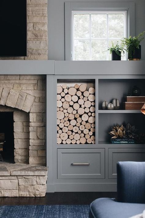 A TV is mounted over a rustic stone fireplace positioned beside gray built-in cabinets positioned under a wood cubby and gray styled shelves. Grey Stone Fireplace, Rustic Stone Fireplace, Fireplace Design Ideas, Built In Around Fireplace, White Brick Fireplace, Fireplace Bookshelves, Built In Shelves Living Room, Living Room Built Ins, Fireplace Built Ins