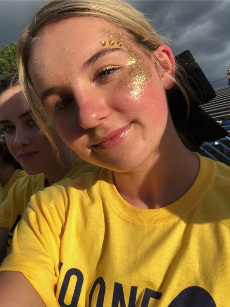 Gold Outfit Football Game, Game Day Glitter Face, Glitter Cheer Makeup, Gold Cheer Makeup, Glitter On Face Football Game, Cheer Makeup High School Glitter, Gold Outfit Spirit Week, Black And Gold School Spirit Outfits, High School Face Paint