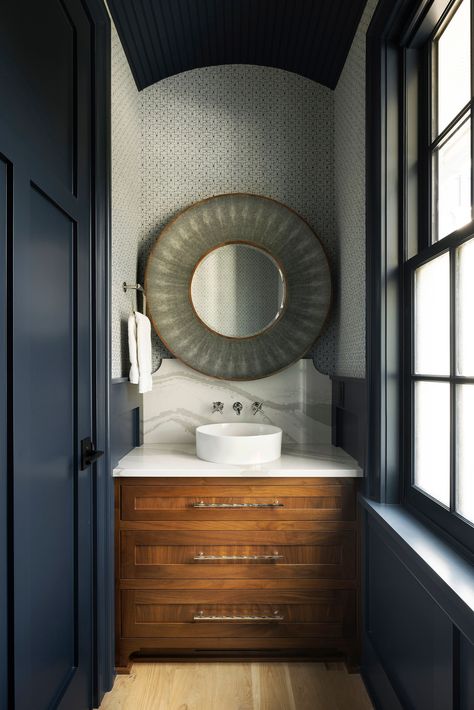 This Medina powder room by Randolph Interior Design features a dramatic dark blue barrel-vaulted ceiling, an enamel wall-mount faucet against a quartz backsplash, walnut cabinets, small-scale wallpaper, and a shagreen mirror. Visit the link below for more powder bath inspiration. 📸: Spacecrafting Dark Blue Powder Room, Powder Room Dark, Blue Beadboard, Blue Powder Room, Villa Style Home, Midwest Home, Barrel Ceiling, Quartz Backsplash, Sliding Screen Doors