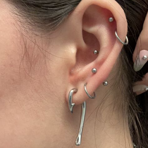 silver jewelry, silver earring stack, fish hook earring, lobe piercings, conch piercing, helix piercings, chrome Fish Hook Piercing, Ear Piercing Styling Silver, Ear Stretching Sizes, Silver Piercings Aesthetic, Silver Helix Piercing, Ear Styling Silver, Ear Curation Silver, Silver Earrings Stack, Silver Piercings Ear