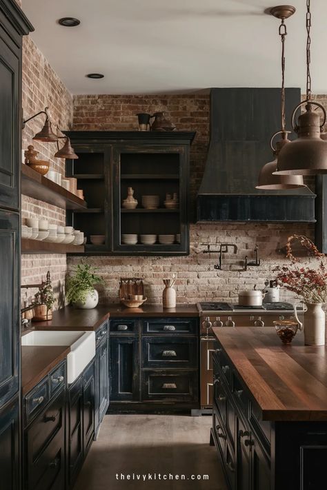 Rustic kitchen with dark cabinets, wooden countertops, exposed brick walls, and copper utensils. Black Cabinets Brick Backsplash, Butcher Block Countertops Dark Cabinets, Dark Cottage Core Kitchen, Dark Cottage Kitchen, Rustic Black Kitchen Cabinets, Black Kitchen Cabinets Butcher Block, Moody Cottage Kitchen, Blank Wall In Kitchen Ideas, Brown And Black Kitchen