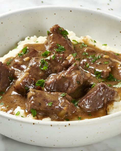 Angled view of beef tips on mashed potatoes, topped with herbs in a white and brown speckled bowl. Meat And Gravy, Speckled Bowl, Beef Tip Recipes, Beef Tips And Gravy, Pot Beef Stew, Beef Stew Meat, Beef Tips, Stew Meat, Beef Chuck