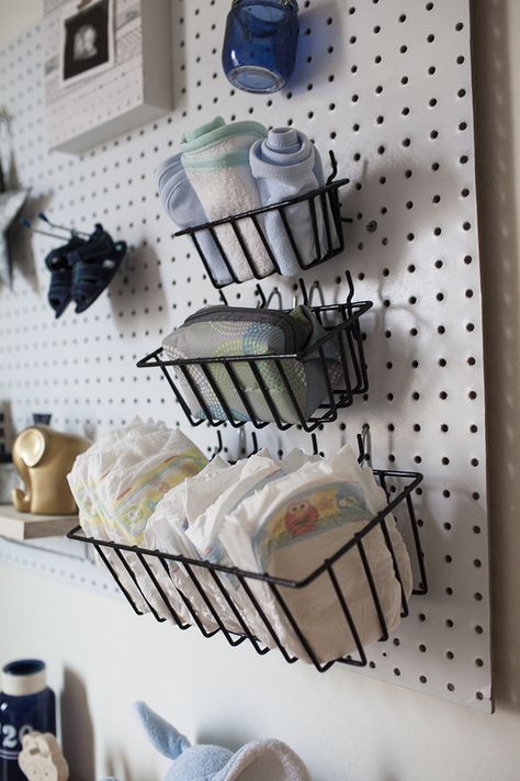 Organize and decorate your baby's nursery at the same time! This nursery peg board is a simple way to store diapers and other newborn essentials. Pegboard In Nursery, Peg Board Nursery Ideas, Peg Board Nursery, Nursery Diy Decor, Pegboard Nursery, Livingroom Ikea, Garage Nursery, Baby Boy Nursery Diy, Nursery Ideas Boy