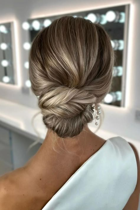 This elegant twisted low bun hairstyle showcases smooth strands with subtle highlights, creating a polished and sophisticated look perfect for upscale events.  // Photo Credit: Instagram @suzannedusekmakeup Smooth Wedding Hair, Bridal Buns Hairstyle, Bridal Low Bun Hairstyles, Bridal Hair Low Bun, Hairstyle Wedding Bridesmaid, Twisted Low Bun, Low Bun Bridal Hair, Low Bun Wedding Hair, Low Bun Hairstyle