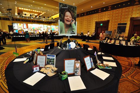 Great set up for an auction item table. Having a display that expresses the cause as a display is genius...it gives the bidder a reason to bid. Auction Table Display Ideas, Silent Auction Table Display, Auction Basket Themes, Running A Silent Auction, Silent Auction Display, Silent Auction Bidding Sheets, Silent Auction Bid Sheets, Tricky Tray, Auction Themes