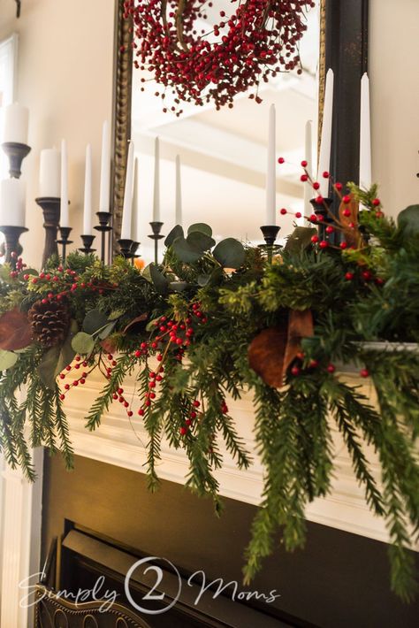 My halls are decked with classic, southern-style charm. Grab a cup of coffee and tour my home that features simple ideas you can easily do in your own home! Includes a cozy front porch, foyer, kitchen, family room with a stunning fireplace mantel, and powder room. #redberries #redberrywreath #cozychristmas #christmas #mantle #centerpiece #traditional #vintage #housetour #bathroom #foyer #kitchen #familyroom #frontporch Traditional Cozy Christmas Decor, Christmas Mantle Traditional, Christmas Mantle With Wreath, Christmas Mantle Decor Traditional, Classic Christmas Fireplace Decor, Classic Christmas Centerpieces, Classic Christmas Mantle Decor, Craftsman Christmas Decor, Christmas Mantle With Candles