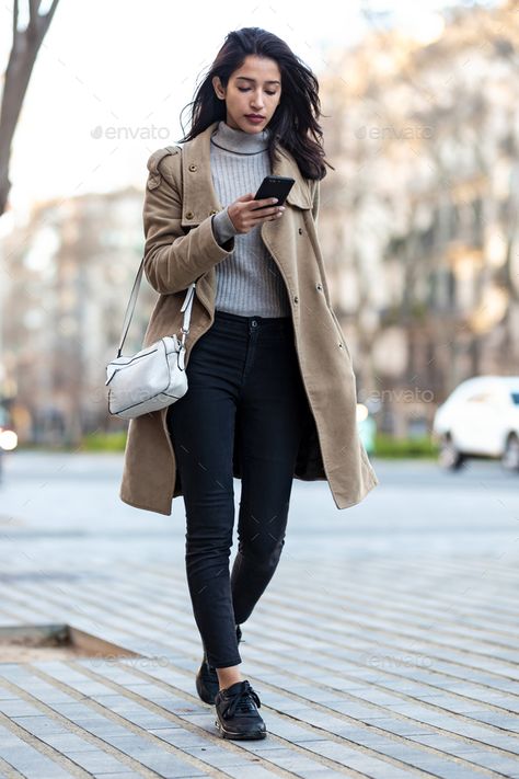 Pretty young woman using her smartphone while walking in the street. by nenetus. Shot of pretty young woman using her smartphone while walking in the street. #Sponsored #woman, #smartphone, #Pretty, #young Walking Female Reference, Girl Walking Reference, Pose Reference Ballet, Woman Walking Reference, Back View Pose Reference, Woman Walking Forward, Person Walking Reference, Phone Poses, Sisters Poses