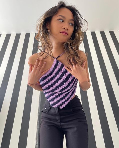 A girl with curly hair wearing a diamond striped lilac and black crochet top. The crochet top is asymmetrical and made by Naradiya. The background is black and white stripes. Crochet Diamond Top, Crochet Diamond, Lilac And Black, Diamond Top, Lemon Peel, Crochet Tops, Self Made, Birthday Girl, Black Top