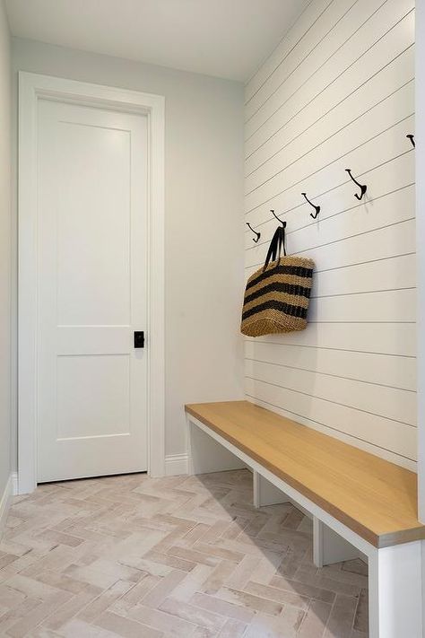 Mudroom features faded hooks on a white shiplap wall above an oak bench with open cubby style storage underneath. Vertical Shiplap Mudroom Bench, Shiplap Entryway With Hooks, Hooks On Bathroom Wall, Shiplap Mudroom Wall With Hooks, Entry Way With Bench And Hooks, Mudroom Coat Hooks, Shiplap Wall With Hooks, Entryway Bench And Hooks, Shiplap Mudroom