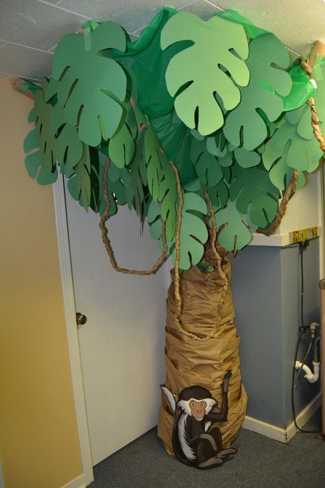 Trunk made with painters paper over tomato cages. Top made with green tablecloth and construction paper leaves on pipe insulation (could use pool noodles). Vines made by twisting painters paper. Photo Jungle, Trunk Diy, Theme Tree, Jungle Theme Classroom, Jungle Decorations, Deco Jungle, Vbs Themes, Diy Leaves, Green Tablecloth