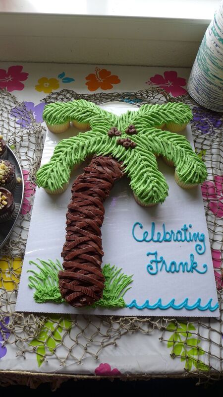 Hawaiian Luau Cupcake Tree Hawaiian Cupcake Cake, Luau Pull Apart Cupcakes, Tiki Cupcakes Hawaiian Luau, Luau Cupcakes Ideas, Hawian Theme Cupcakes, Luau Cupcake Cake, Beach Pull Apart Cupcake Cake, Pineapple Dessert Ideas, Beach Cupcake Cake