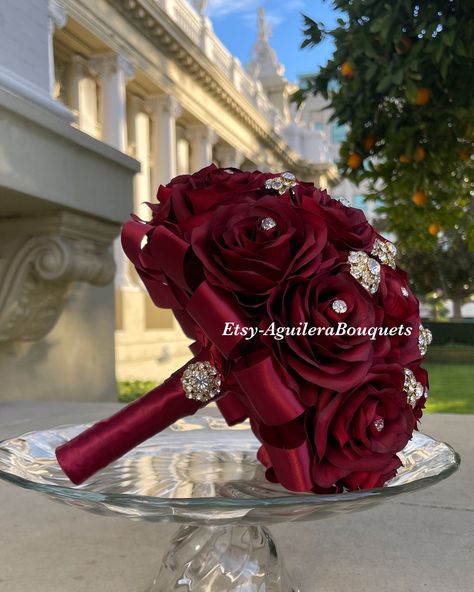 This bouquet is handmade with burgundy roses with sparkling gold brooches. The handle of the bouquet is wrapped with satin ribbon. The design can be change if requested. I can do it in different colors. Please message me if the color is not listed.  *This bouquet is 10 inches in diameter*  If you need the bouquet sooner please sent me a message.  Please contact me if you have any questions:) Thank you so much! Burgundy 15 Decorations, Quince Ramos Red, Quince Decorations Burgundy, Flowers For Quinceanera, Burgundy Quinceanera Decorations, Burgundy Quince Dress, Quinceanera Dresses Maroon, Burgundy Quinceanera Theme, Burgundy Quince Dresses