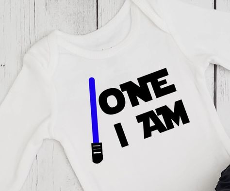 Boys 1st birthday shirt in Star Wars theme. One I am and light saber in your color choice. Custom designs available. One With The Force Birthday Party, The Force Is Strong With This One 1st Birthday, Star Wars 1st Birthday, 1st Birthday Onesie, Birthday Onesie, Baby Birthday Themes, One Year Birthday, Birthday One, Star Wars Birthday Party