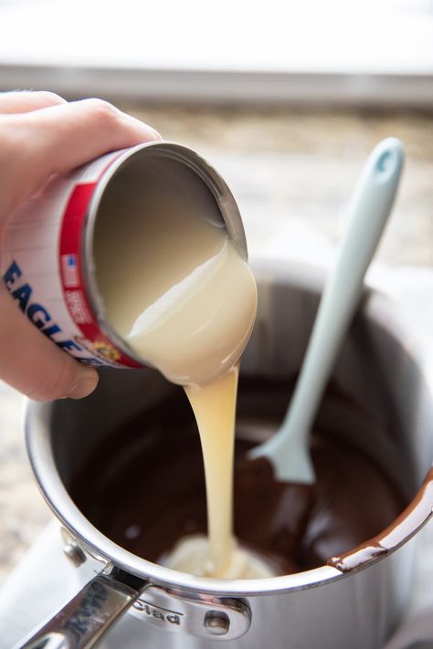 pouring sweetened condensed milk into melted chocolate Melting Chocolate In Crock Pot For Dipping, Diy Chocolate Fondue, Halloween Chocolate Fountain Ideas, Chocolate Fountain Recipe Easy, Melting Pot Dipping Sauces, Melt Chocolate Chips For Dipping, Dipping Chocolate Recipe, Chocolate Fondue Dippers, Desert Sauces