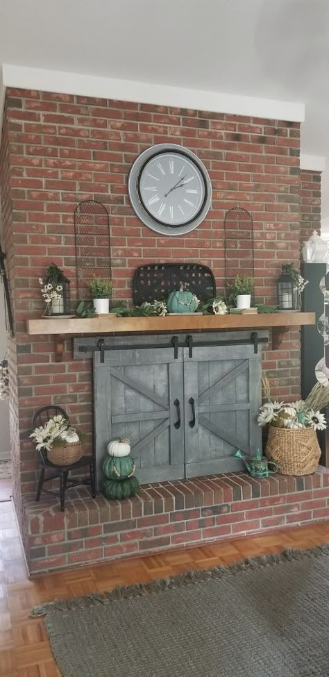 Hubby took my idea and made these, removable, barn doors to hide our original glass fireplace doors. They are meant for show only and do not slide. They lift off, easily, when we decide to use the fireplace in cold weather. They co-oridinate perfectly with the original ones, that he made for the door and windows, on the opposite side of the living room.    I'm so happy and proud of his talent and patience... it was a bit of a challenge getting it customized, but we did it!        Fire… Make Barn Doors, Glass Fireplace Doors, Farmhouse Fireplace Decor, Making Barn Doors, Fireplace Glass Doors, Fireplace Diy, Fireplace Cover, Fireplace Doors, Brick Fireplace Makeover