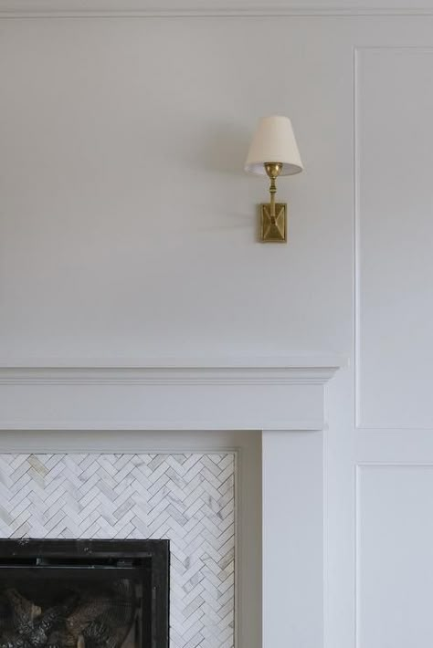 A Jane Wall Sconce is mounted above a white fireplace mantel fixed framing carrera marble herringbone surround tiles. Herringbone Tiles Fireplace, Herringbone Fireplace Surround, White Fireplace Mantel, Herringbone Tile Fireplace, Studio Mcgee Fireplace, Herringbone Fireplace, White Fireplace Mantels, Kitchen Living Rooms, Fire Surrounds