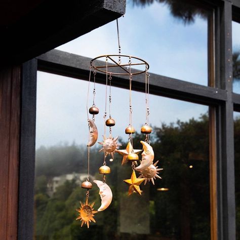 Sun, Moon, and Stars Mobile Bring the sun, moon and stars into your own backyard with this celestial mobile. The circular mobile, which also features bells, chimes gently when it sways in the breeze. The natural-colored pendants go well with just about every style of home and garden, making this piece a great gift for friends and family. Like all Happy Gardens mobiles, this item has been individually handcrafted. Features Of This Mobile *Sound Of Product In Video Is Taken In A Gusting Wind* Dime Whimsy Interior, Wind Chimes Aesthetic, Celestial Mobile, Howls Bedroom, Universal Codes, Marceline Fashion, Circle Mobile, Stars Mobile, Witch Room