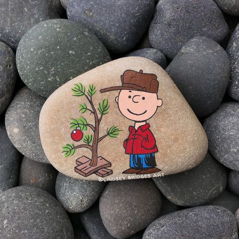 Charlie Brown Christmas painted rock  by Lindsey Bridges #christmasrock #christmasrockpainting #charliebrownrockpainting #paintedrock #rockpainting #charliebrownchristmas #charliebrownrock #paintedstone #stonepainting #rockart #artrock #stoneart Snoopy Christmas Painted Rocks, Charlie Brown Painted Rocks, Christmas Painted Rocks, Charlie Brown Christmas Tree, Christmas Rocks, Painted Rocks Kids, Rock And Pebbles, Brown Christmas, Christmas Rock