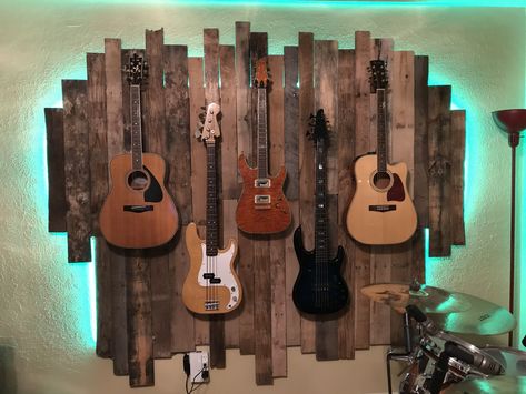 Guitar wall display LED pallet wall #palletwall #pallets #guitardisplay Guitar On Wall Decor, Display Guitars On Wall, Hanging Guitars On Wall Ideas, Guitar Wall Display, Guitar Hanging Ideas Diy, Guitar Hanging On Wall, Guitar Wall Stand, Guitar Hanging Ideas, Guitar Shelf Diy Wall Shelves