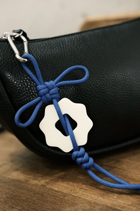 Unleash your creativity with the Ama Talisman DIY keychain kit!  This beautifully simplistic knotted charm, engraved with our logo 'coin', is perfect for adding a touch of good fortune to your bags or sacred spaces.  Crafted with high-quality Perspex (10-year scratch resistance), stainless steel, and durable nylon paracord, this kit lets you create your own unique talisman.  Choose from various colors and personalize your good luck charm. Approx. 30cm L x 8cm W knot, 5cm charm. Keychain On Bag, Bag Charms Diy, Bag Accessories Keychain, New Year Accessories, Diy Bag Charm, Coin Keychain, Goods Design, Accessory Inspo, Paracord Keychain