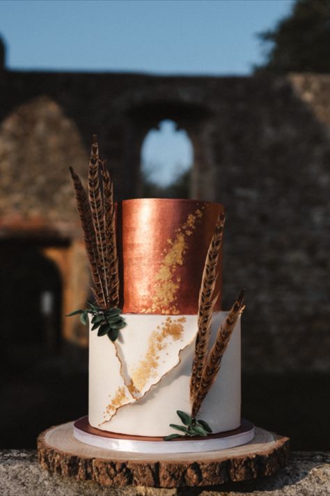 Copper Boho luxury iced wedding cake with feathers, gold and green foliage. Rustic wedding theme. Church Ruins, Essex, bohemium outdoor wedding. Emerald Green And Burnt Orange Wedding Cake, Green And Orange Wedding Cake, Emerald And Copper Wedding, Copper And Green Wedding, Dark Green Wedding Cakes, Copper Wedding Cake, Copper Wedding Theme, Iced Wedding Cake, Brown Wedding Cakes