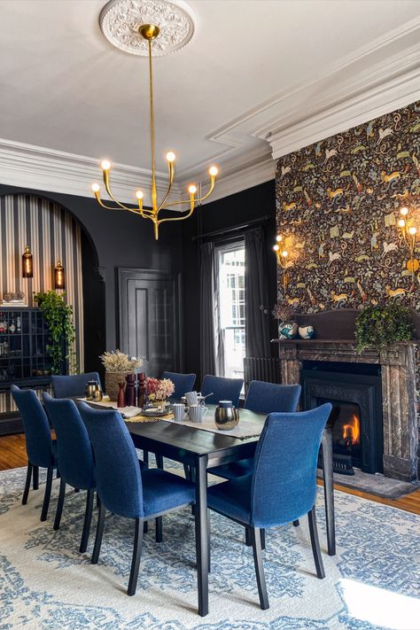 Step back in time in our client's beautifully preserved 1850's dining room. Our team added a fresh touch with dark walls, elegant lighting, and a mix of heirloom furnishings. A large floor mirror and two distinct wallpapers bring drama and whimsy to the space. Comfortable seating and a wool rug complete the timeless look. Dark Traditional Dining Room, Gold And Blue Dining Room, Rock And Roll Dining Room, Large Artwork Dining Room, Dark Wallpaper Dining Room, Dark Walls Dining Room, Blue Dinning Rooms, Color Drenched Dining Room, Jewel Tone Dining Room